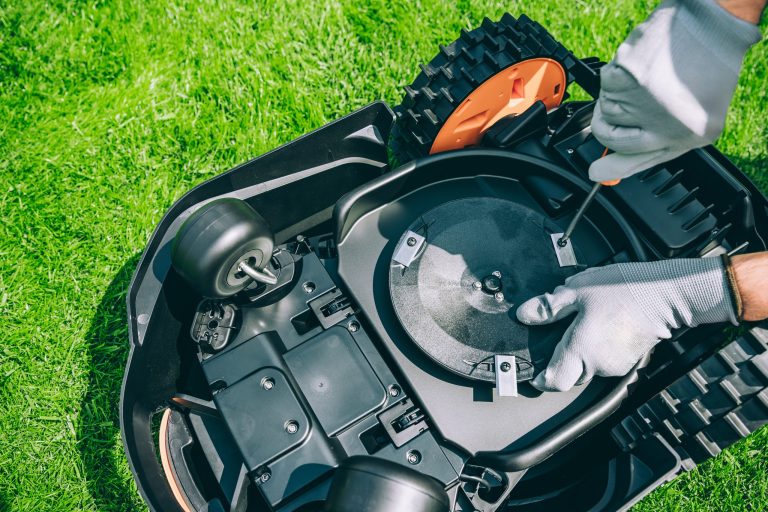 Technicien Proxinord configurant un robot tondeuse Husqvarna dans un jardin des Weppes