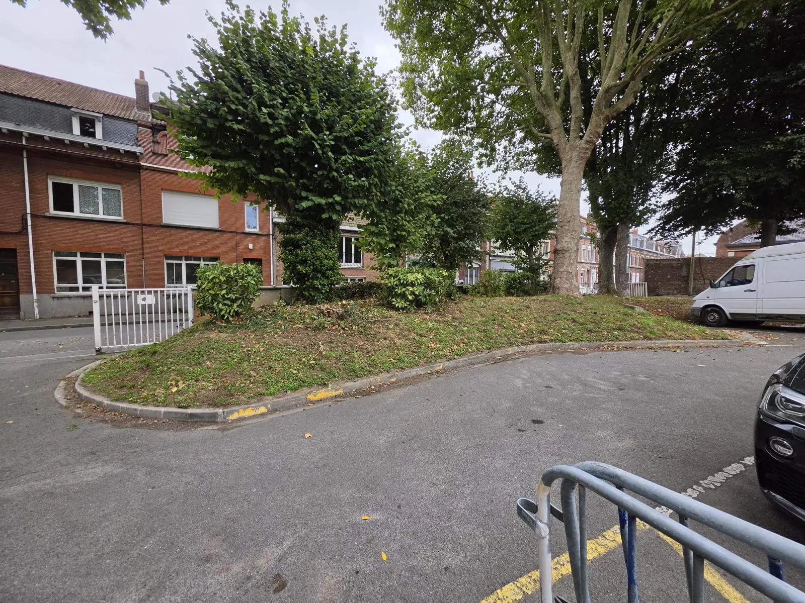 Entretien espaces verts Haubourdin : îlot d'angle taillé côté voirie, abords du parking dégagés