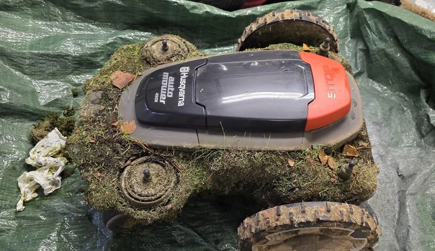 Châssis d'un robot tondeuse Husqvarna Automower 450X couvert de mousse avant nettoyage, atelier de Hallennes-lez-Haubourdin