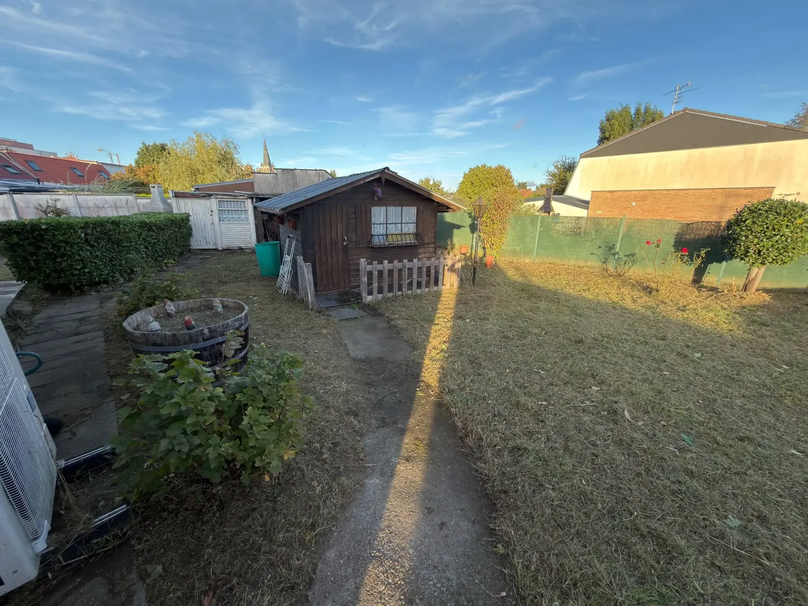Remise en état jardin Hallennes-lez-Haubourdin : pelouse fauchée et tondue devant un chalet de jardin en bois