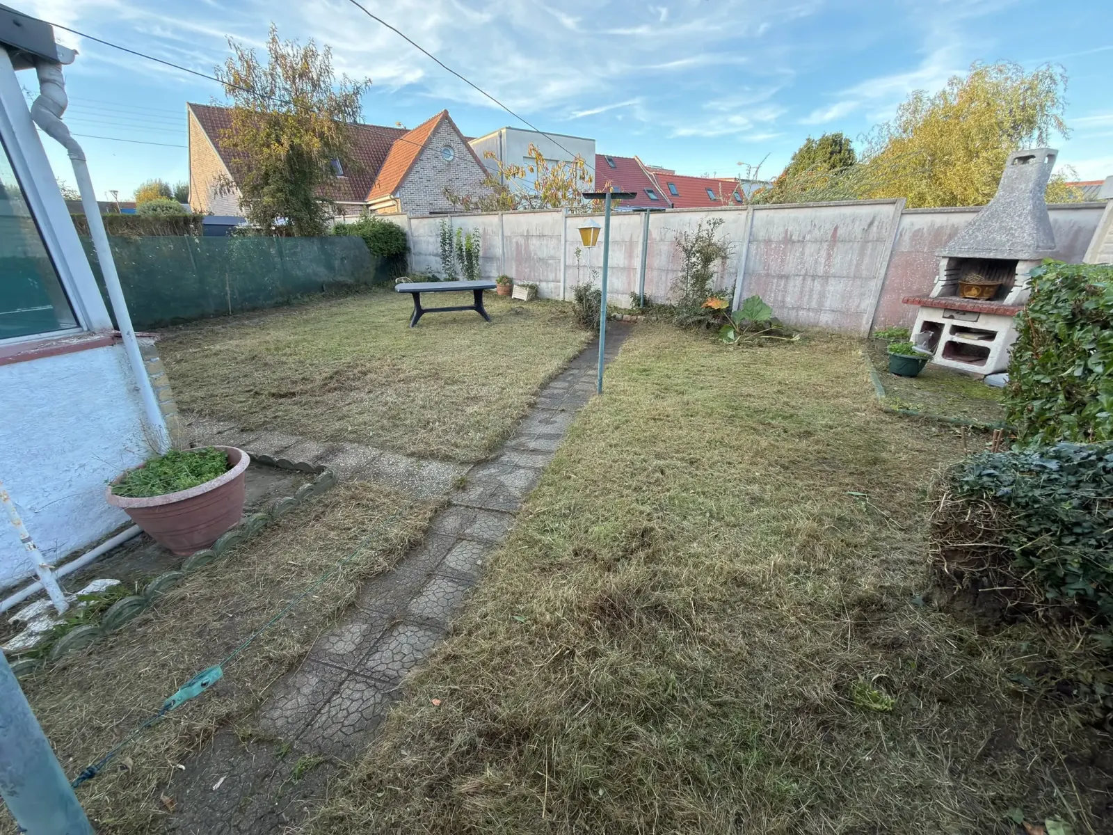 Remise en état jardin Hallennes-lez-Haubourdin : jardin fauché et tondu, allée en dalles dégagée jusqu'au barbecue